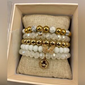 Nicole Miller 5 stack beaded stretchy bracelets. Gold and white beads w/ charms